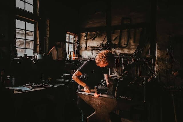 A person crafting a tool with a hammer